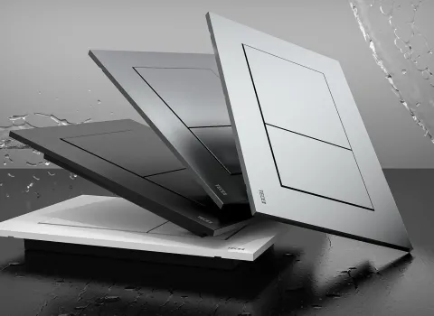 Die WC-Betätigungsplatten der Serie TECEnow, präsentiert in Schwarz, Grau und Weiß, liegen schräg aufeinander auf einer feuchten, reflektierenden Oberfläche.