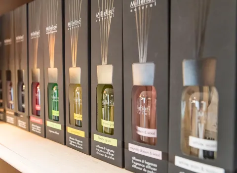 Mehrere Duftdiffuser der Marke Millefiori stehen in einer Regalreihe nebeneinander.