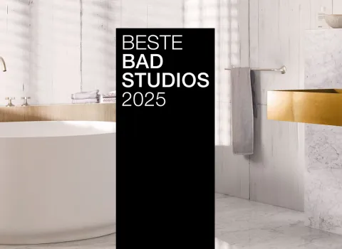 Ein stilvolles Bad mit goldenen Armaturen, Marmorwaschtisch und freistehender Badewanne. Ein schwarzer Banner mit "Beste Badstudios 2024" ist prominent im Bild.