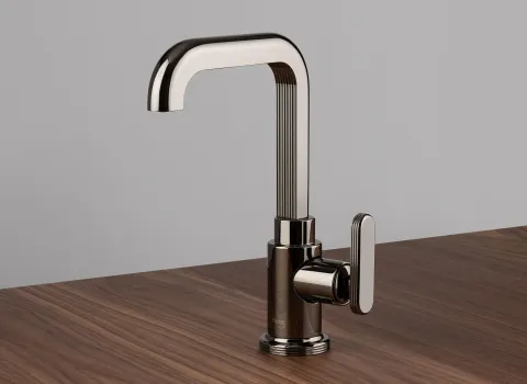 Ein einzelner Wasserhahn der Serie Frattini Parklane steht auf einer Holzoberfläche und besticht durch seine elegante Kombination aus glatten und gerillten Elementen.