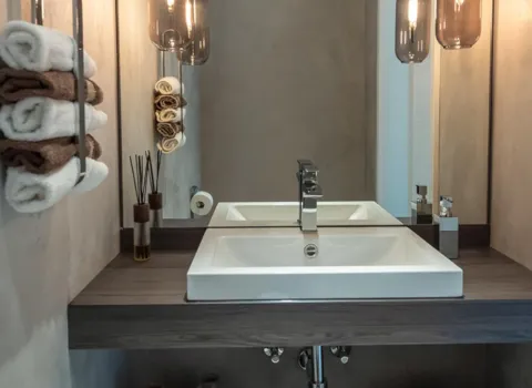 Ein modernes Badezimmer mit Doppelwaschbecken und stilvoller Holzverkleidung unter dem Waschtisch.