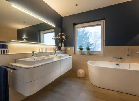 Ein luxuriöses Badezimmer mit freistehender Badewanne und schwebendem Doppelwaschbecken im eleganten Weiß.