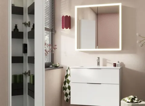 Ein moderner Waschtisch burgbad Eqio in glänzendem Weiß steht vor einer hellen Wand und wird von einem rechteckigen Spiegel RL20 mit umlaufender LED-Beleuchtung ergänzt.
