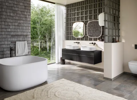 Modernes Designbad mit freistehender Badewanne Zencha von Duravit, Doppelwaschtisch und großen Fenstern mit Naturblick.