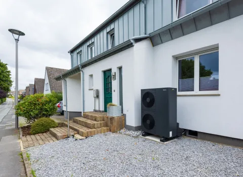 Bestands-Wärmepumpe vor Einfamilienhaus.