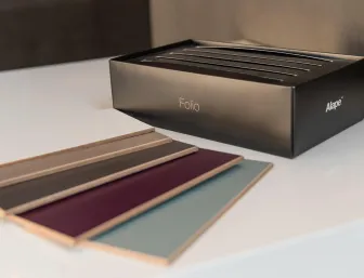 Auf einem weißen Tisch liegt eine elegante Musterbox mit dem Schriftzug „Folio“ der Marke Alape.