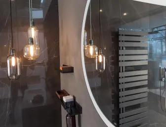 Ein modernes Badezimmer mit dunkler Marmorwand und elegantem Heizkörper im Lattenstil. 