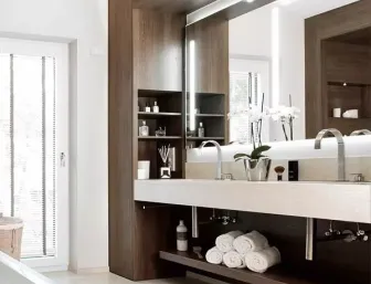 Ein eleganter Doppelwaschtisch mit großem Spiegel und integrierter LED-Beleuchtung steht im Zentrum dieses modernen Badezimmers. 