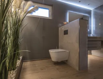 Ein modernes Badezimmer mit wandhängendem WC, das durch seine klare Linienführung und die warme Holzoptik am Boden besticht.