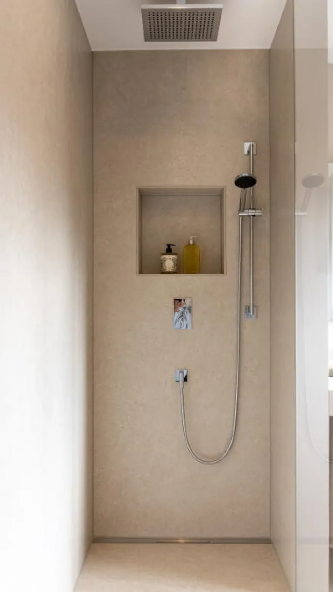 Die minimalistisch gestaltete Dusche ist vollständig in beige gehalten und wirkt durch ihre klare Linienführung besonders modern. 