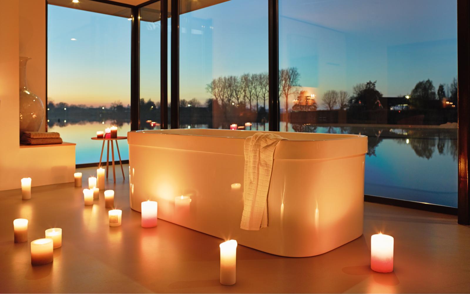 Whirlwanne vor großem Fenster im Kerzenschein